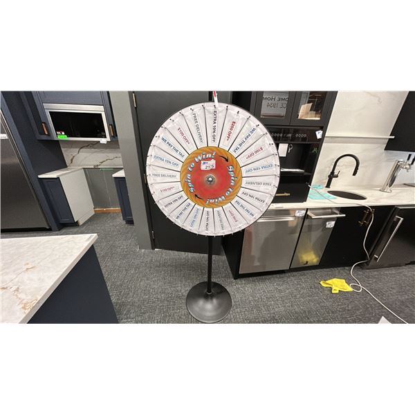 SPIN TO WIN WHEEL OF FORTUNE. 34" DIAMETER WHEEL MOUNTED ON A FLOOR STAND 71" HIGH.