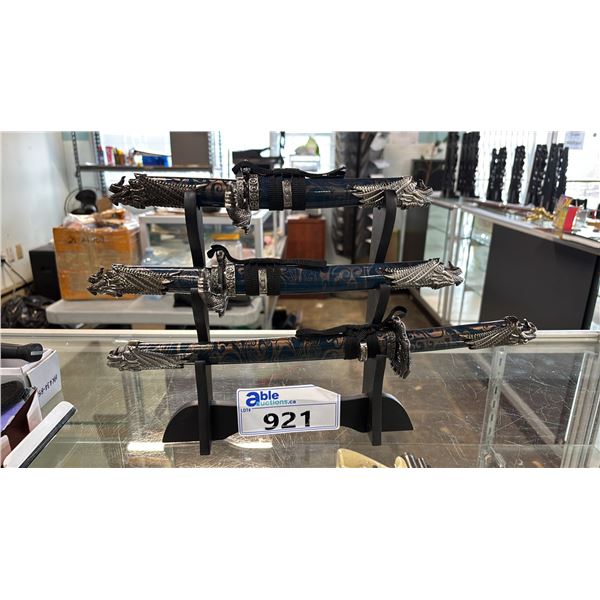 (3) DECORATIVE DAGGERS OF DIFFERENT LENGTHS ON A STAND