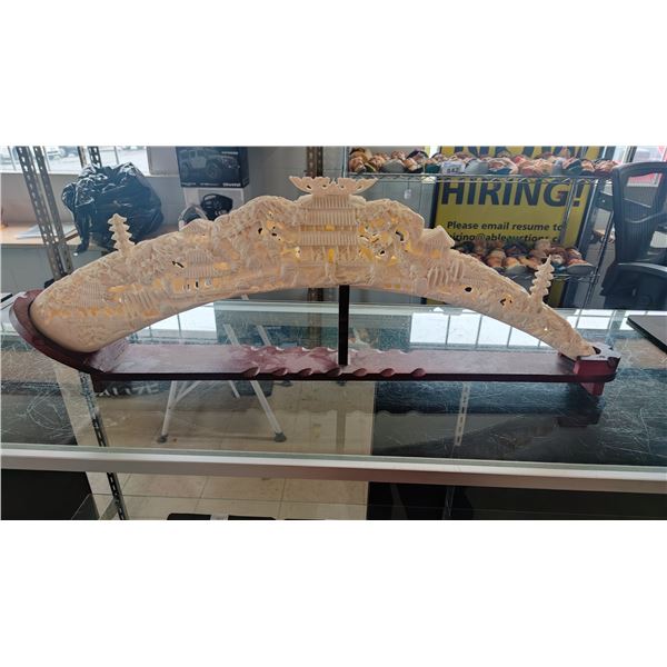 FAUX IVORY CARVED TUSK ON MAHOGANY STAND
