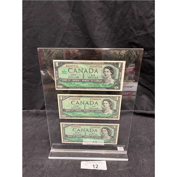 3 mint condition 1954 Canadian dollar bills in display stand