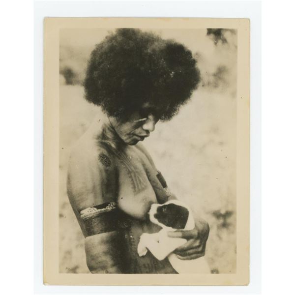 African Woman Breastfeeding a Dog Photo