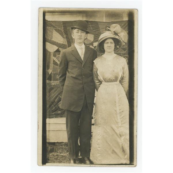 Young Couple Posing in Front of Crazy Quilt RPPC