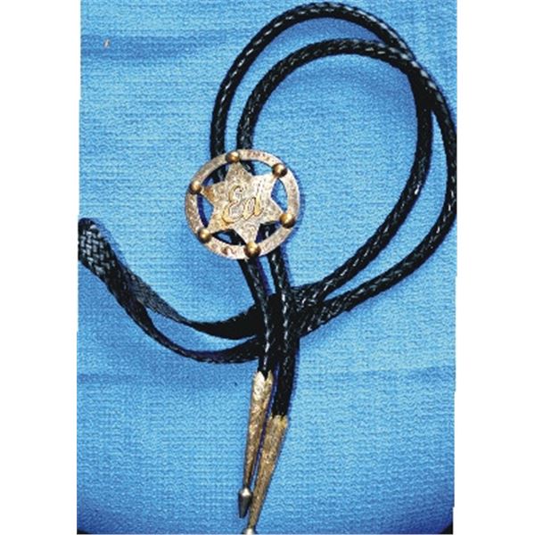 Bolo tie with silver badge engraved with ED