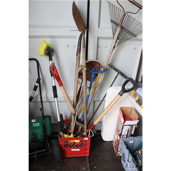 Selection of gardening tools including sprinklers, shovel, fork, shears, rakes, etc