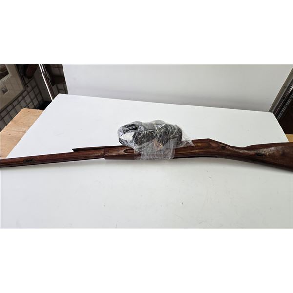 Selection of Mosin Nagant rifle parts including stock, leather strap, oil can, partial cleaning kit,