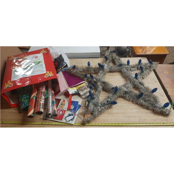 Collection of Christmas decorations and wrapping supplies, including a large, star-shaped tinsel lig