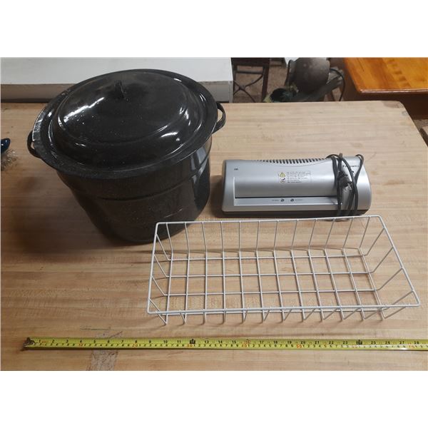 Collection of household items, including a large black cooking pot with a lid, a silver laminator, a