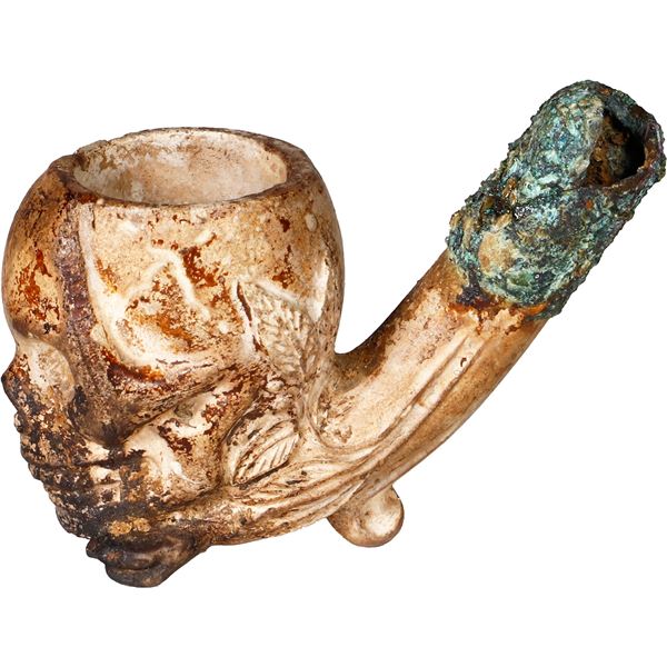Ornate, skull-shaped clay pipe with cuprous stem, 1600s-1700s.