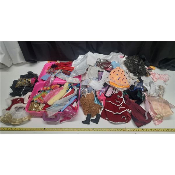 Collection of Vintage Doll Clothes of Different Sizes In Pink Case.