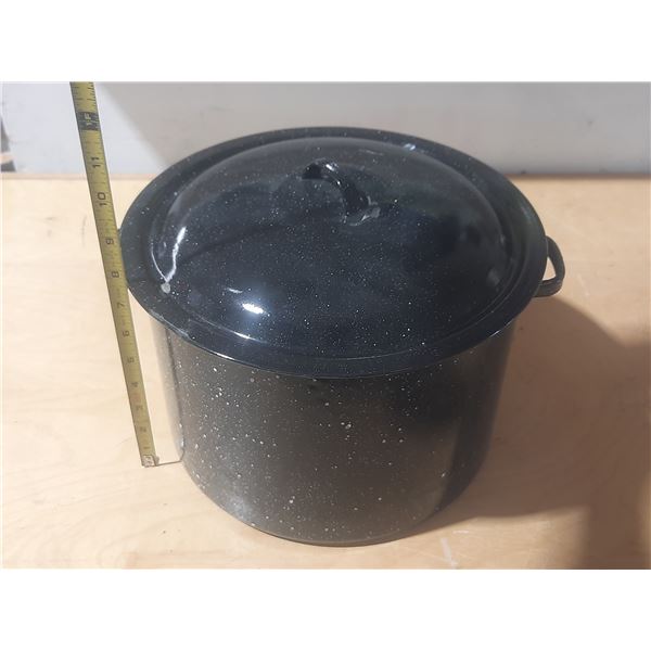 Vintage black speckled enamelware stock pot with a lid.
