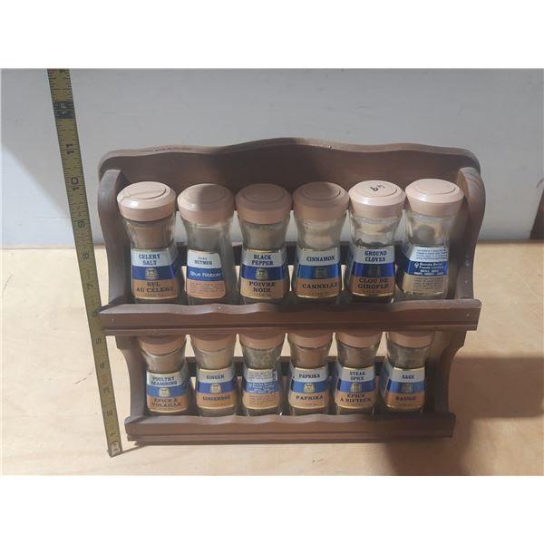 Vintage Blue Ribbon wooden spice rack featuring 12 glass spice jars with spice. (One is Empty)