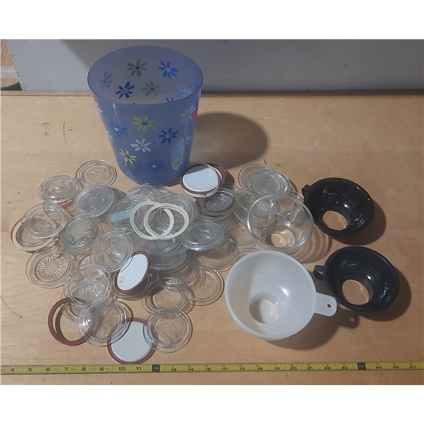 Vintage canning jar components, including glass lids, rubber rings, and a patterned plastic containe
