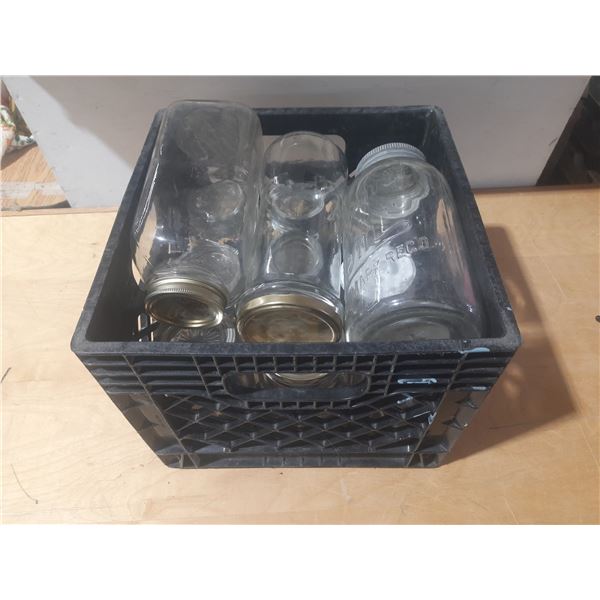 Collection of vintage glass canning jars, commonly known as Mason jars, housed within a black plasti