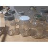 Image 5 : Collection of vintage glass canning jars, commonly known as Mason jars, housed within a black plasti