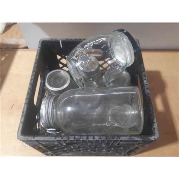 Collection of vintage glass canning jars, commonly known as Mason jars, housed within a black plasti