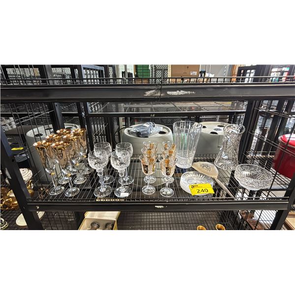 SHELF OF ASSORTED GLASSWARE: CHAMPAGNE GLASSES, WINE GLASSES, DESERT PLATES, VASE & MORE
