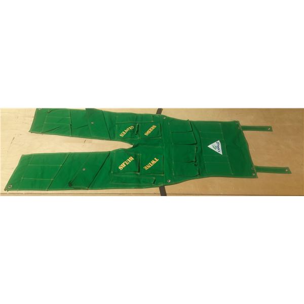This is a green canvas gardener’s apron featuring dedicated pockets for bulbs, twine, seeds