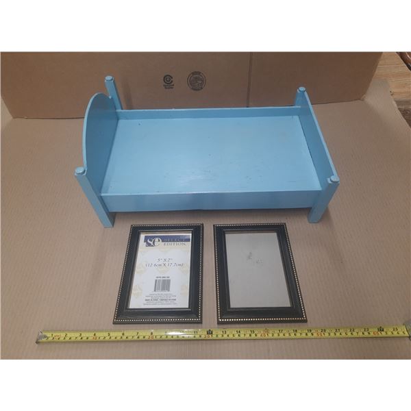 Blue wooden doll bed and photo frames.