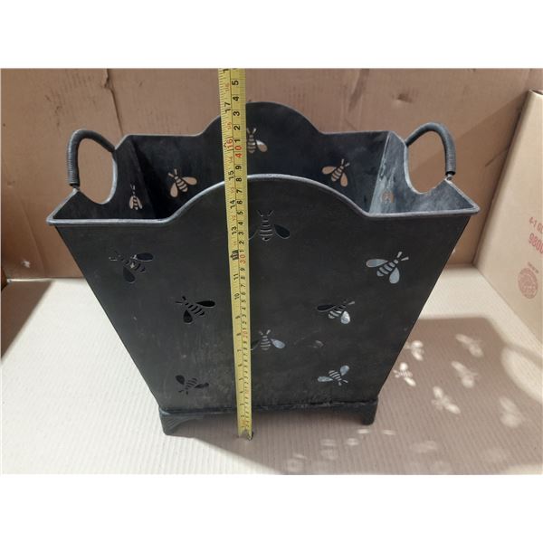 Black metal decorative Magzine Rack with a bee cutout design and side handles.