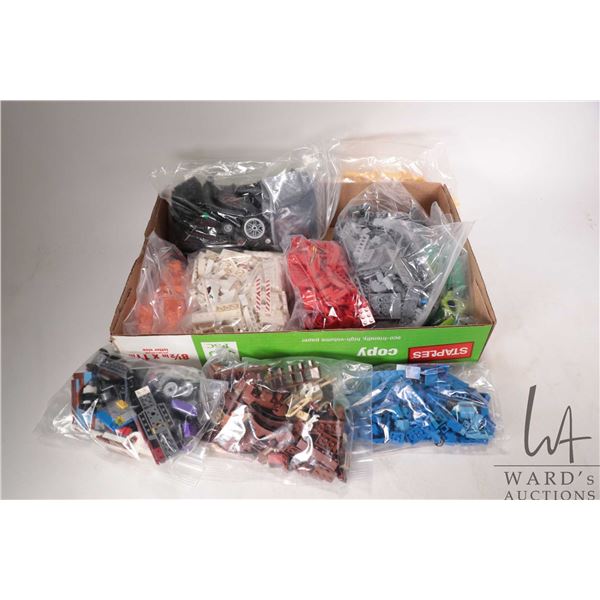 Large selection of Lego building bricks including vehicle parts, separated into colours