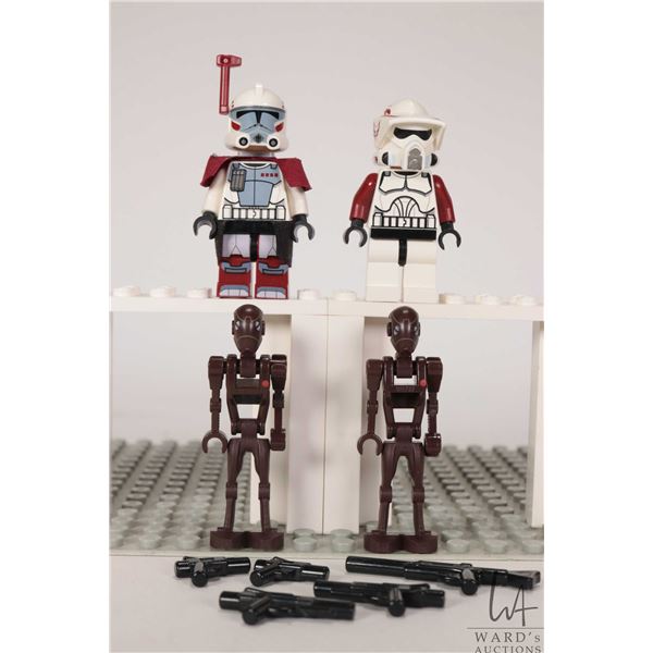 Four Lego Star Wars minifigures including Clone ARC Trooper, Clone ARF Trooper, two Commando Droids.