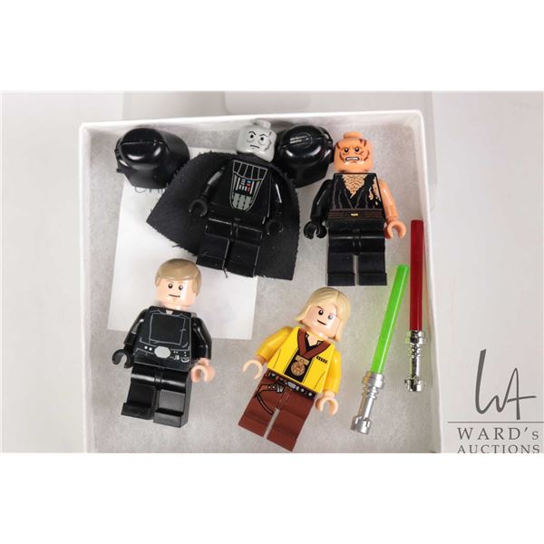 Four Lego Star Wars minifigures including Darth Vader, Anakin Skywalker damaged/burned, Luke Skywalk
