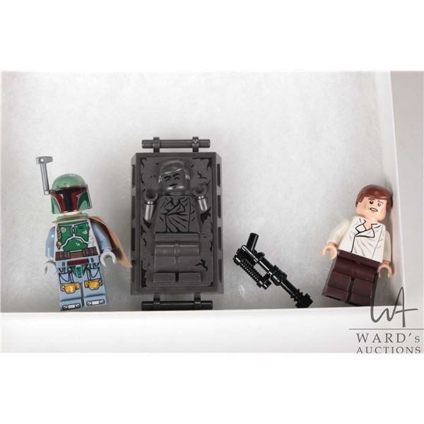 Three Lego Star Wars minifigures including Boba Fett, Han Solo, Han Solo in Carbonite