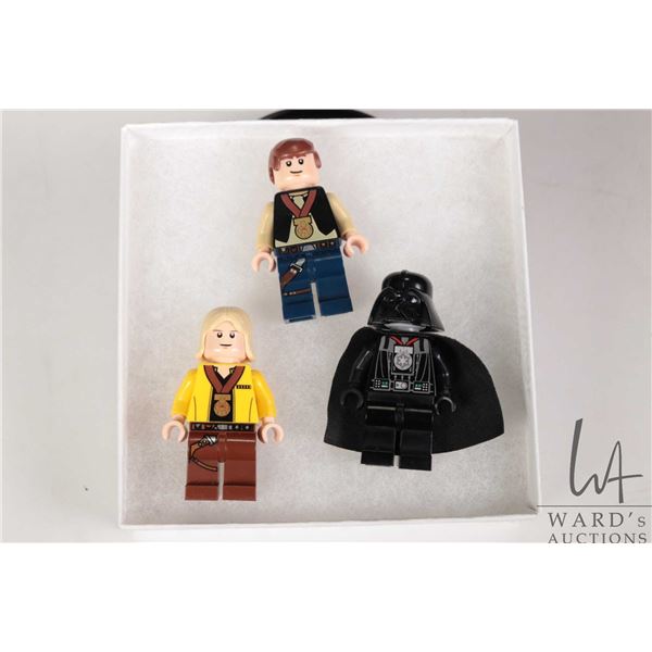 Three Lego Star Wars minifigures including Celebration Luke Skywalker, Celebration Han Solo, and Cel