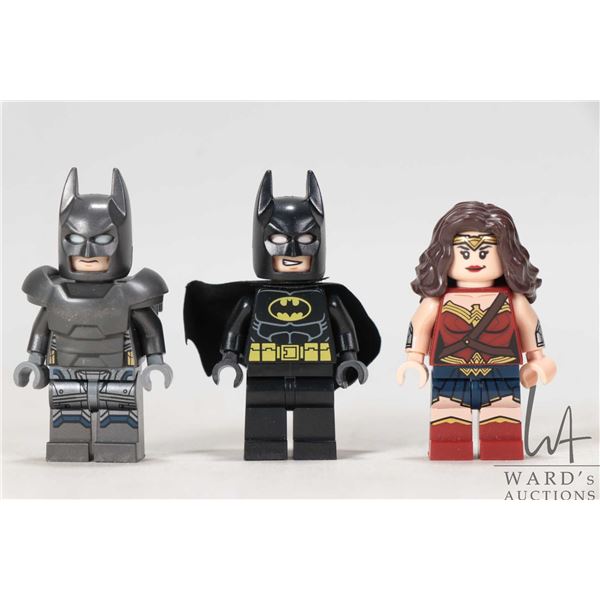 Three Lego Batman minifigures including Batman in armor, Batman, Wonder Woman.