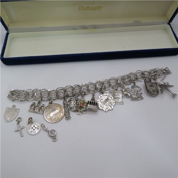 925 vintage charm bracelet with 17 charms. (13 attached & 4 extras).  Marked sterling