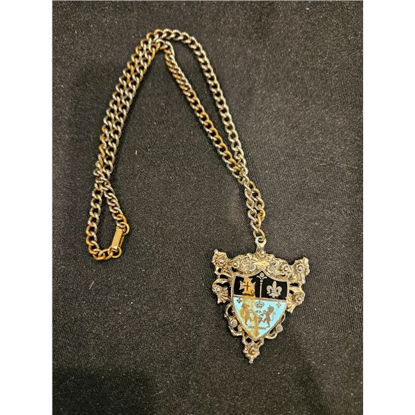 Crest pendant on heavy chain