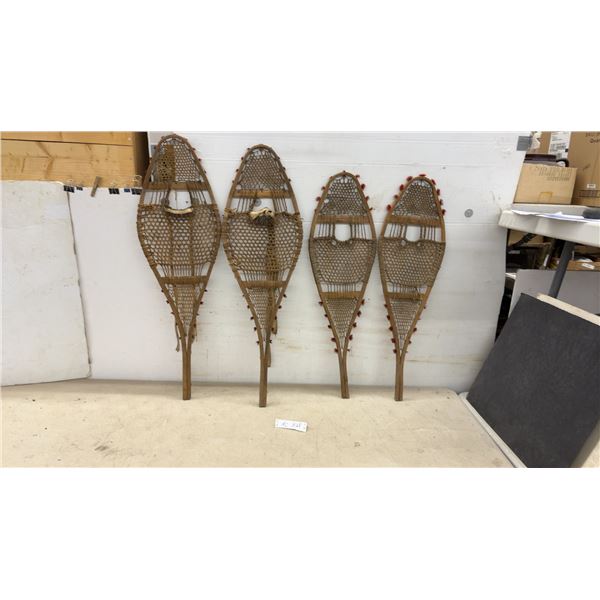 Two Pairs of Traditional Wooden Snowshoes with Rawhide Webbing and Red Pompom Accents