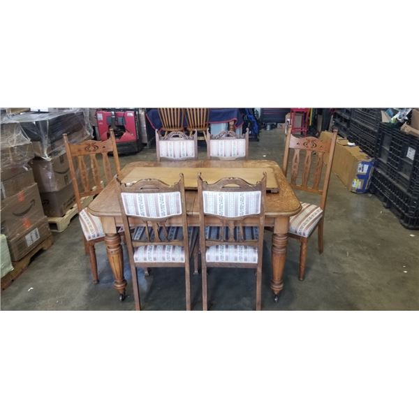 ANTIQUE OAK DINING TABLE WITH ORIGINAL PORCELAIN WHEELS AND 6 DINING CHAIRS WITH EXTENSION LEAF