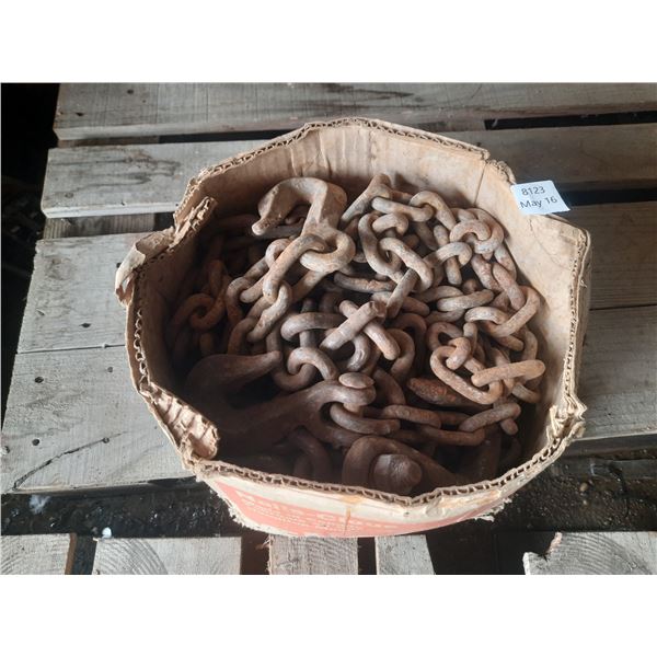 Heavy-duty, rusted industrial chain in box.