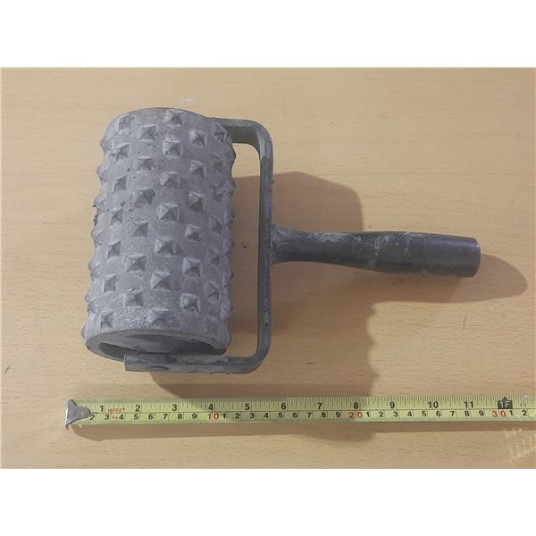 Spiked roller, specifically used for concrete and flooring applications.