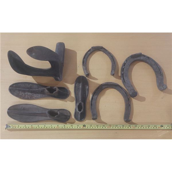 Various types of antique farrier and blacksmith tools, including several horseshoes and cobbler's sh