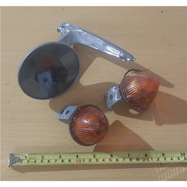 Vintage motorcycle turn signal indicator lights and a mirror.