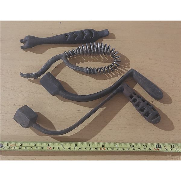 Vintage cast iron stove lid lifters and grate shakers used for wood-burning stoves.