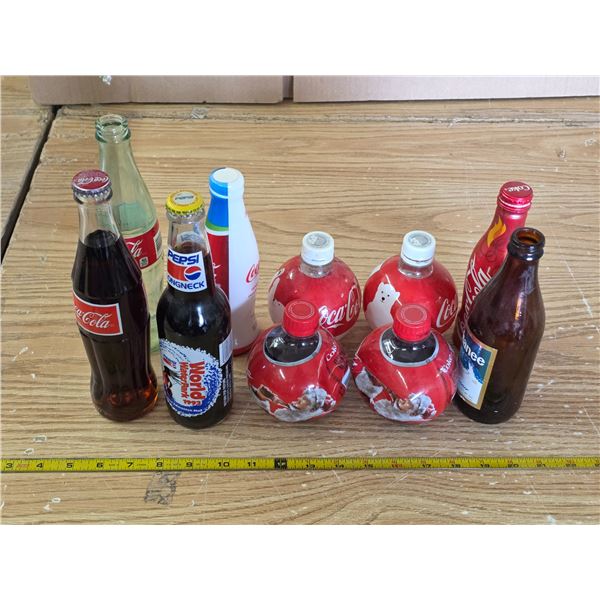 Pop bottles- some are full- coke and pepsi