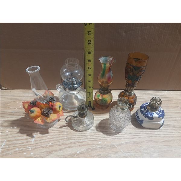 This is a collection of vintage oil and kerosene lamps, featuring various designs and glass styles.