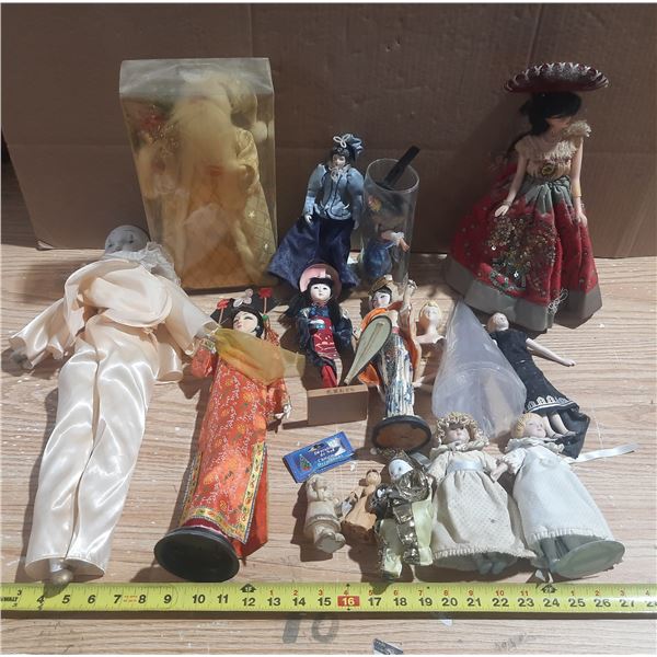 This is a collection of various vintage porcelain dolls, including Japanese geisha dolls, a harlequi