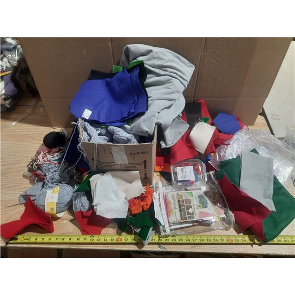 Collection of raw crafting materials, including various colorful fabric and bundles of yarns.