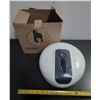 Image 1 : White wall-mounted center-feed roll paper dispenser featuring a central black panel for easy paper d