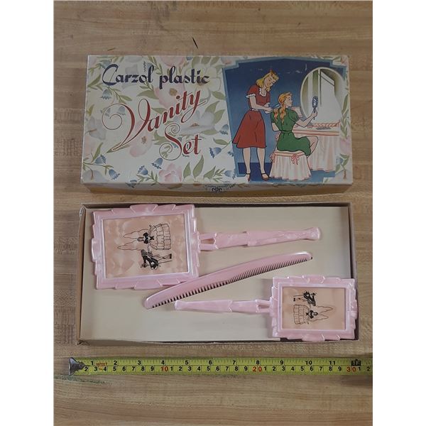 Vintage Carzol plastic vanity set including a pink brush, mirror, and comb.