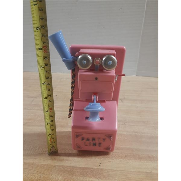 Vintage pink plastic party line telephone toy and money bank.