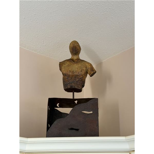 brutalist-style wood and iron bust sculpture.