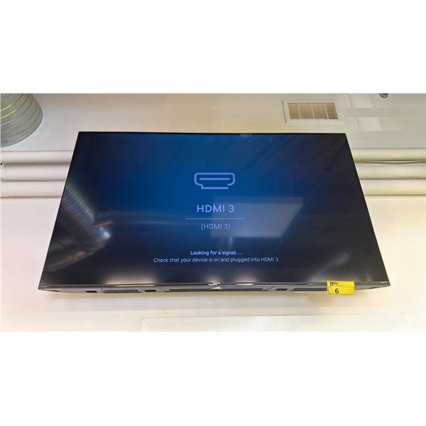 HISENSE TV MOUNTED TO WALL WITH POWER CORD & REMOTE
