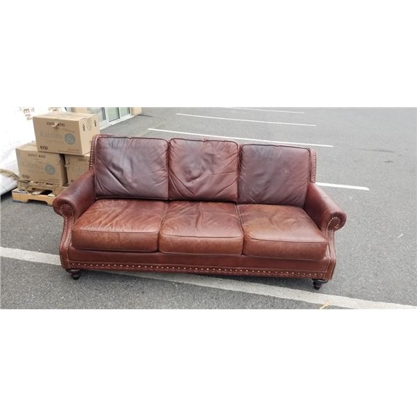 BROWN LEATHER SOFA WITH BRASS NAIL HEAD ACCENTS, SHOWS SIGNS OF WEAR