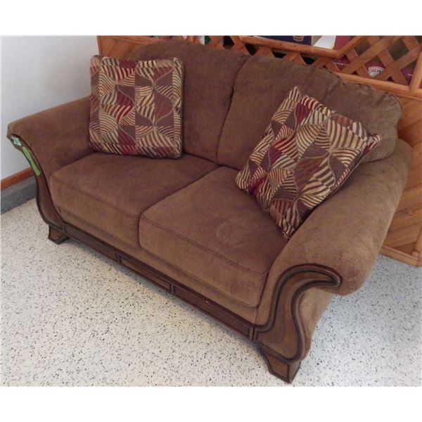 Upholstered loveseat brown in color with pillows