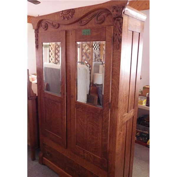 Antique oak armoire with mirrored doors and carved detailing